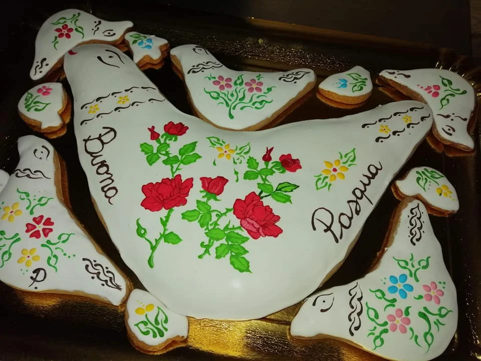 Hand-decorated Geraci Siculo Easter dove biscuit with floral motifs on white icing