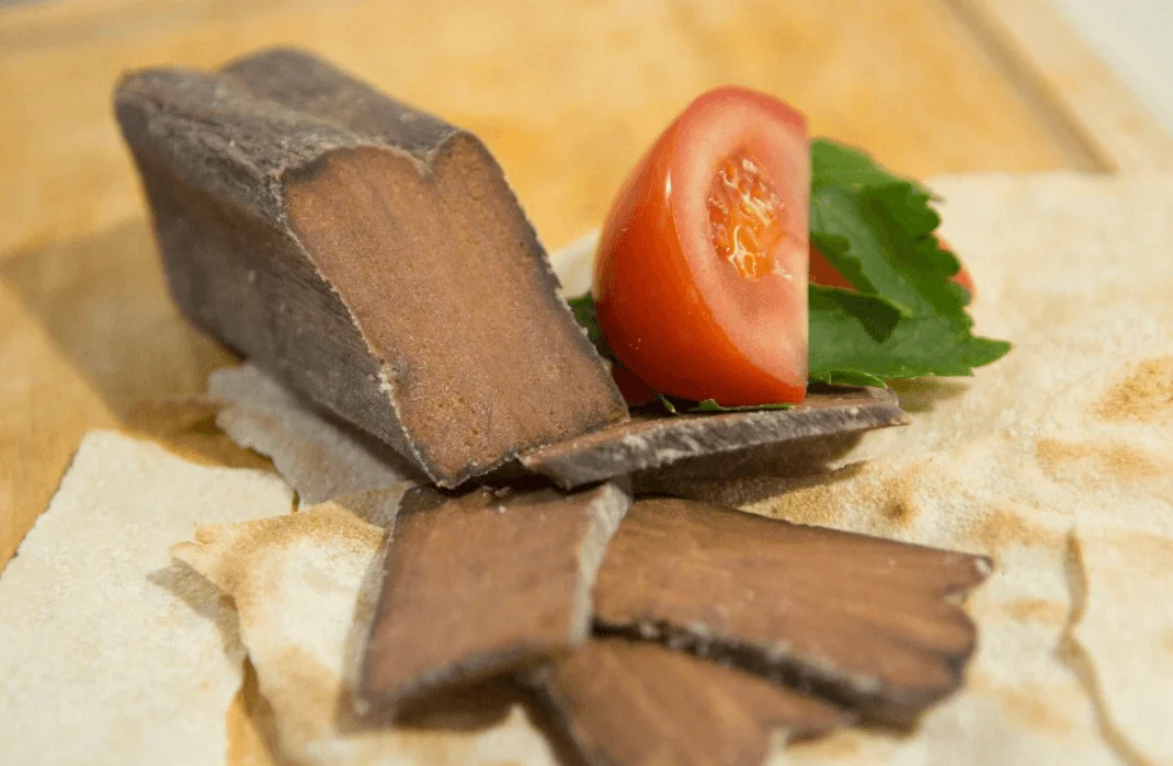 Thin slices of tuna bottarga dressed with oil and lemon on Sicilian ceramic plate