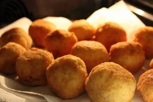 Arancine siciliane con ricotta su piatto di ceramica decorato