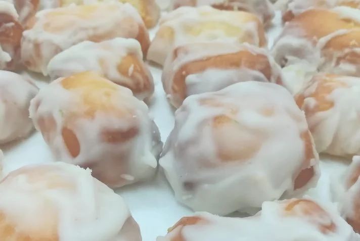 Biscotti regina catanesi glassati al limone disposti su piatto di ceramica siciliana