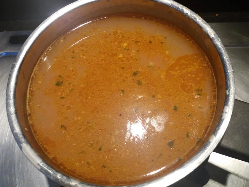 Bowl of grouper broth served with toasted bread and fresh parsley