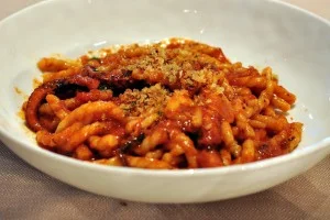 Busiate with octopus ragù served on Sicilian ceramic plate