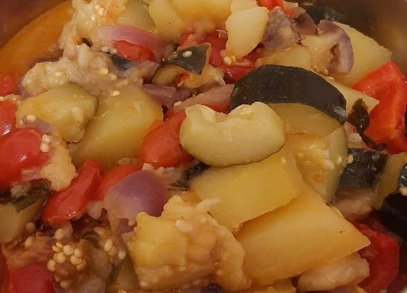 Sicilian Canazzo with colourful vegetables and fresh basil served in a terracotta bowl