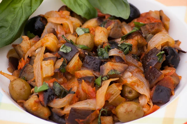 Aubergine caponata served in a Sicilian ceramic bowl