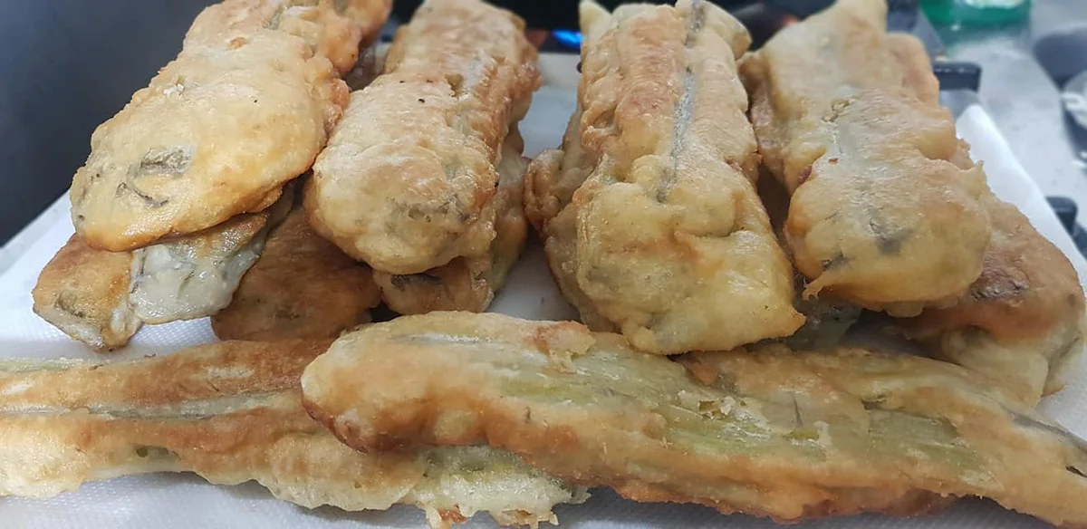 Crispy batter-fried cardoons served warm on a rustic Sicilian plate
