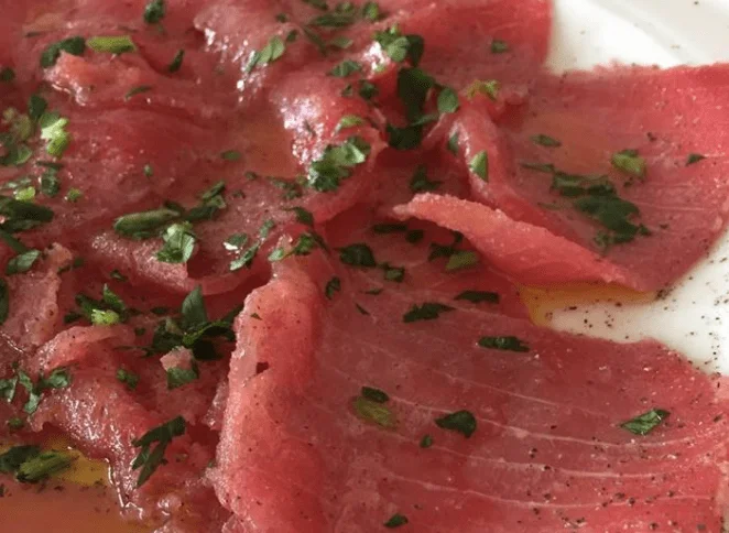 Tuna carpaccio dressed with herbs, lemon and Sicilian olive oil