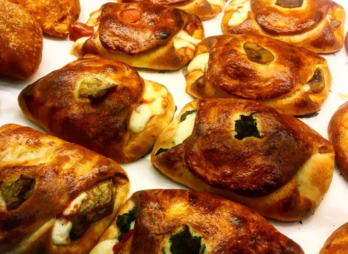Catanese cartocciate filled with tomato, ham and tuma on traditional Sicilian ceramic plate