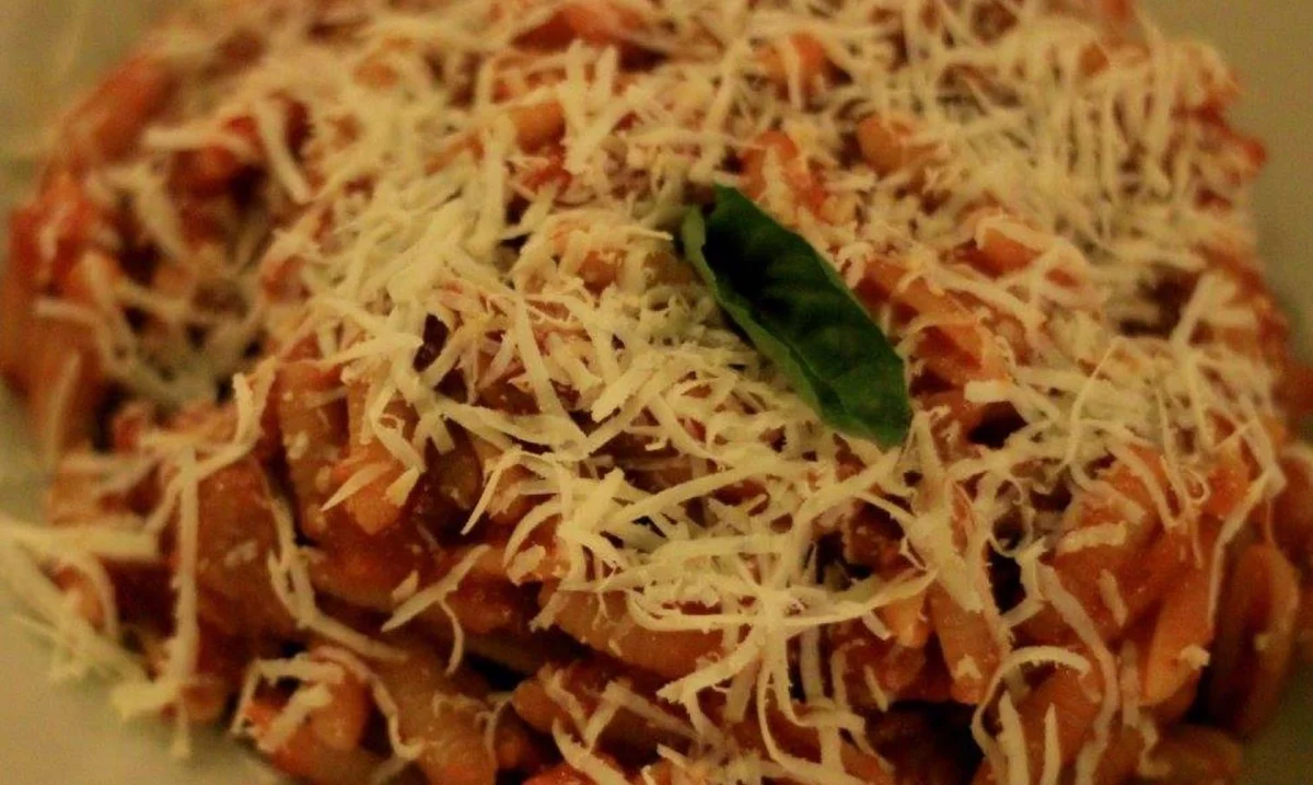 Cavatelli all’agrigentina con melanzane fritte, pomodoro e ricotta salata su piatto di ceramica siciliana