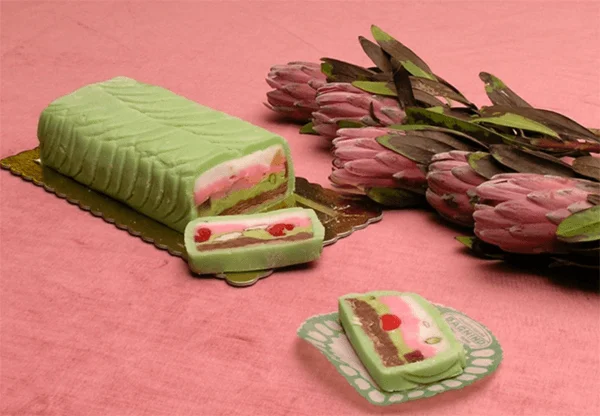 Gelato di campagna siciliano a strati colorati con mandorle e pistacchi su un tagliere di legno