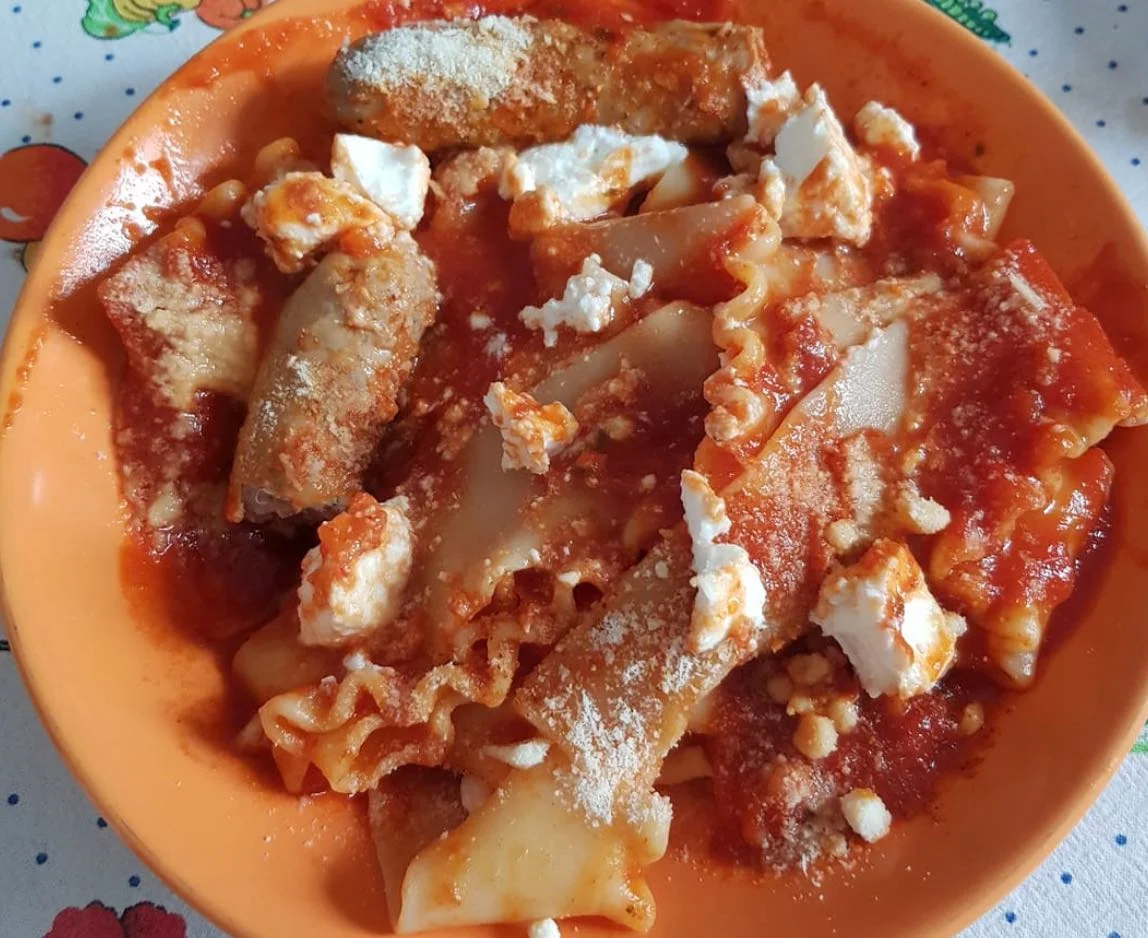 Lasagne cacate con ricotta e ragù siciliano servite in piatto di ceramica tradizionale