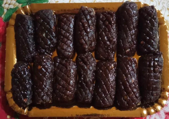 Biscotti mastazzola di Riesi su vassoio rustico con foglie di alloro e sciroppo di carrube