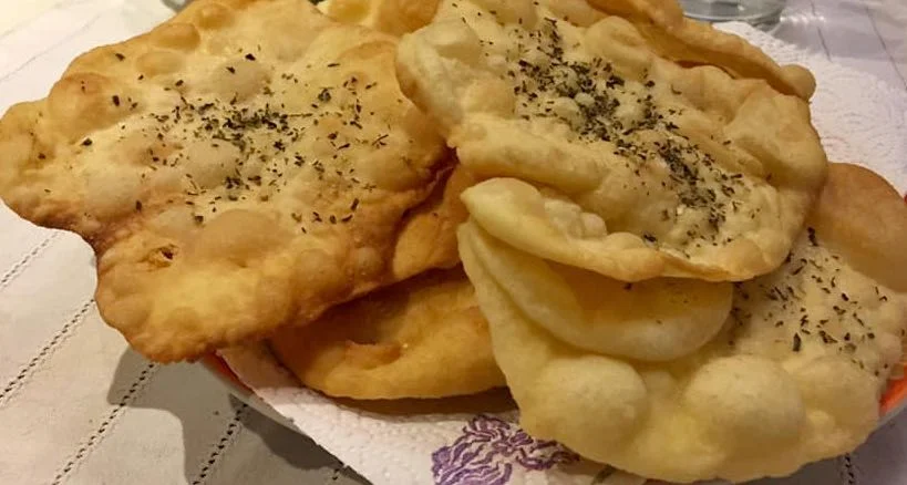 Mitilugghie siciliane dorate e fragranti servite su vassoio rustico