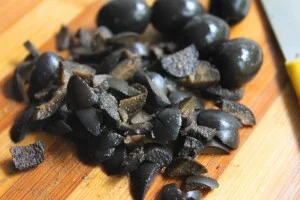 Olive nere infornate condite con olio e origano in ciotola di terracotta