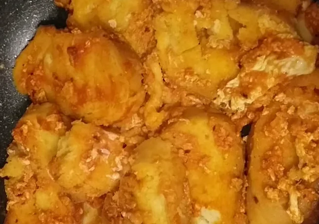 Pani cû pipi di Buccheri servito in piatto rustico con sugo di pomodoro e formaggio fuso