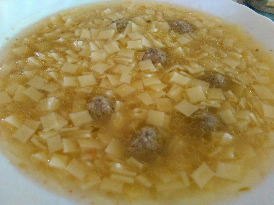 Pasta con polpettine in brodo servita in pentola di terracotta