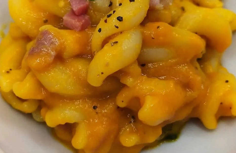 Pasta con crema di zucca e pancetta servita in ciotola rustica siciliana