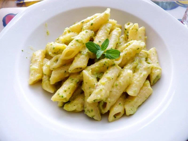 Pasta con crema di zucchine e capperi servita in piatto di ceramica siciliana