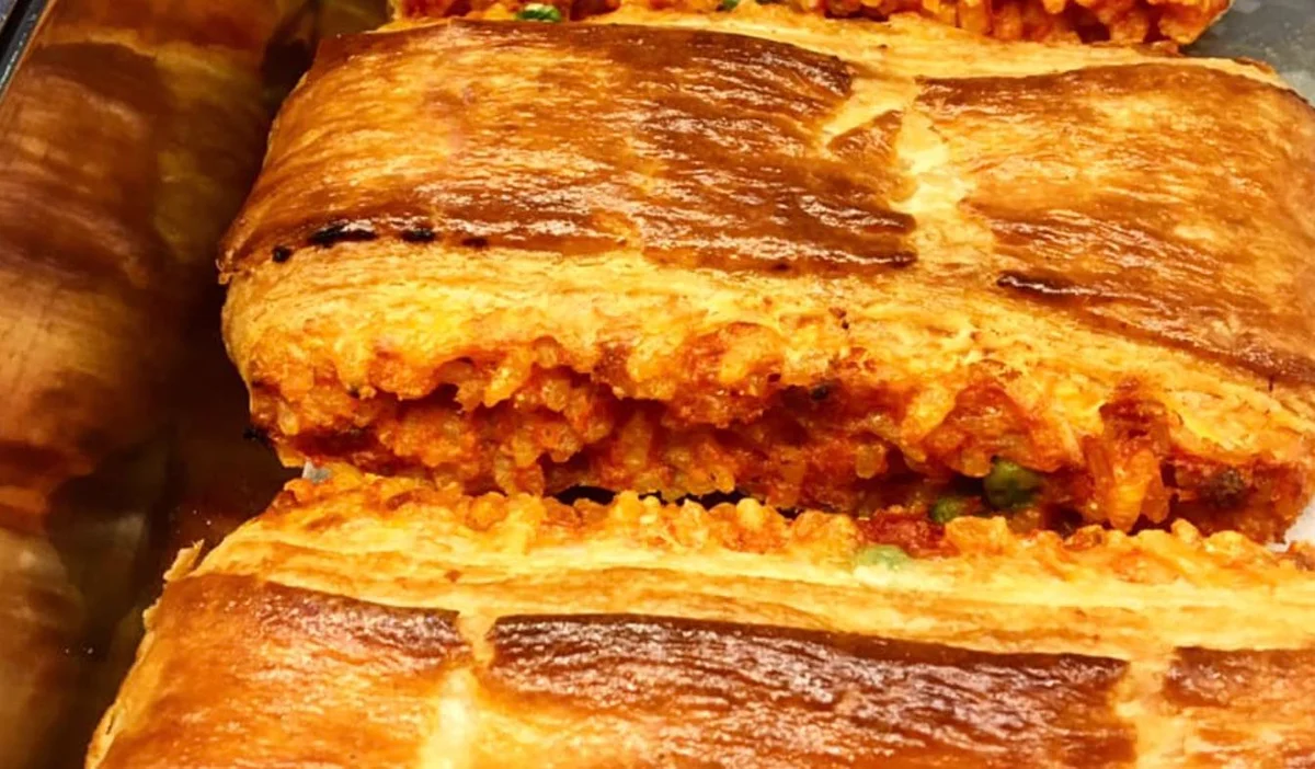 Paté di riso catanese dorato con ripieno di riso, ragù e tuma su piatto di ceramica siciliana