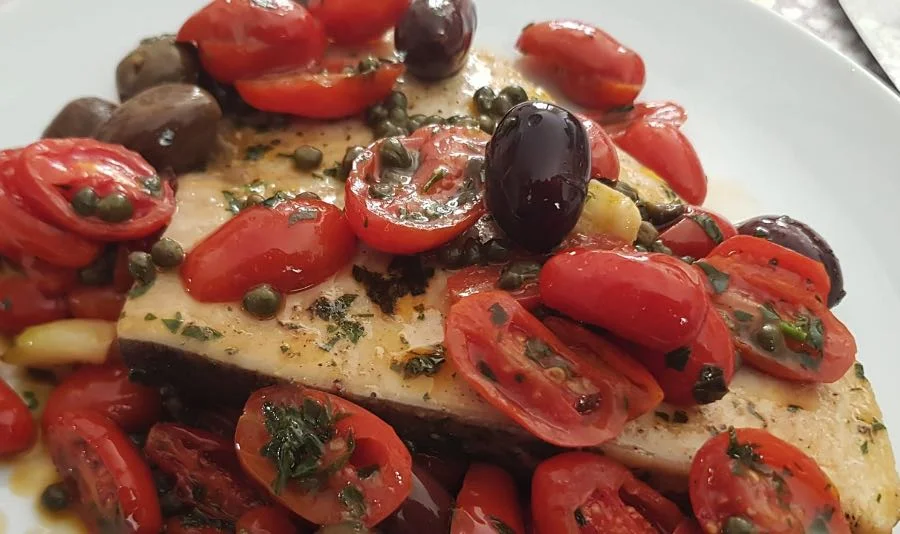 Sicilian-style swordfish cooked with tomatoes, olives and capers