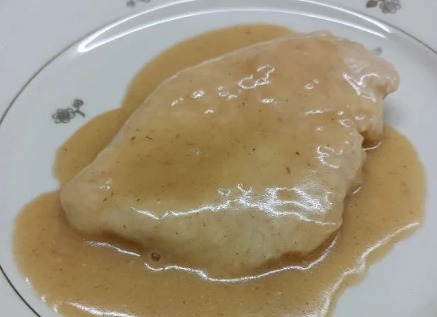 Petto di pollo al limone servito con fette di limone e prezzemolo fresco