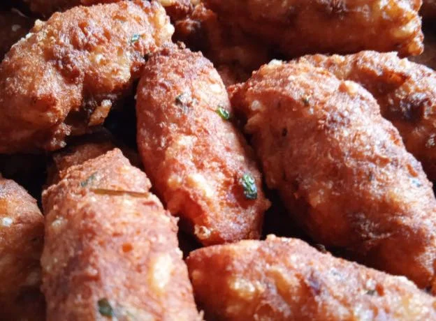 Polpette di riso ragusane dorate e croccanti su piatto di ceramica siciliana