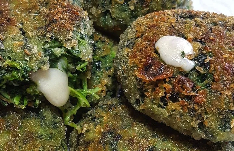 Golden spinach fritters served on Sicilian ceramic plate