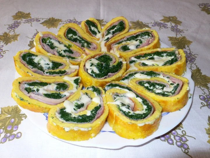 Rotolo di frittata agli spinaci affettato e servito su piatto in ceramica siciliana