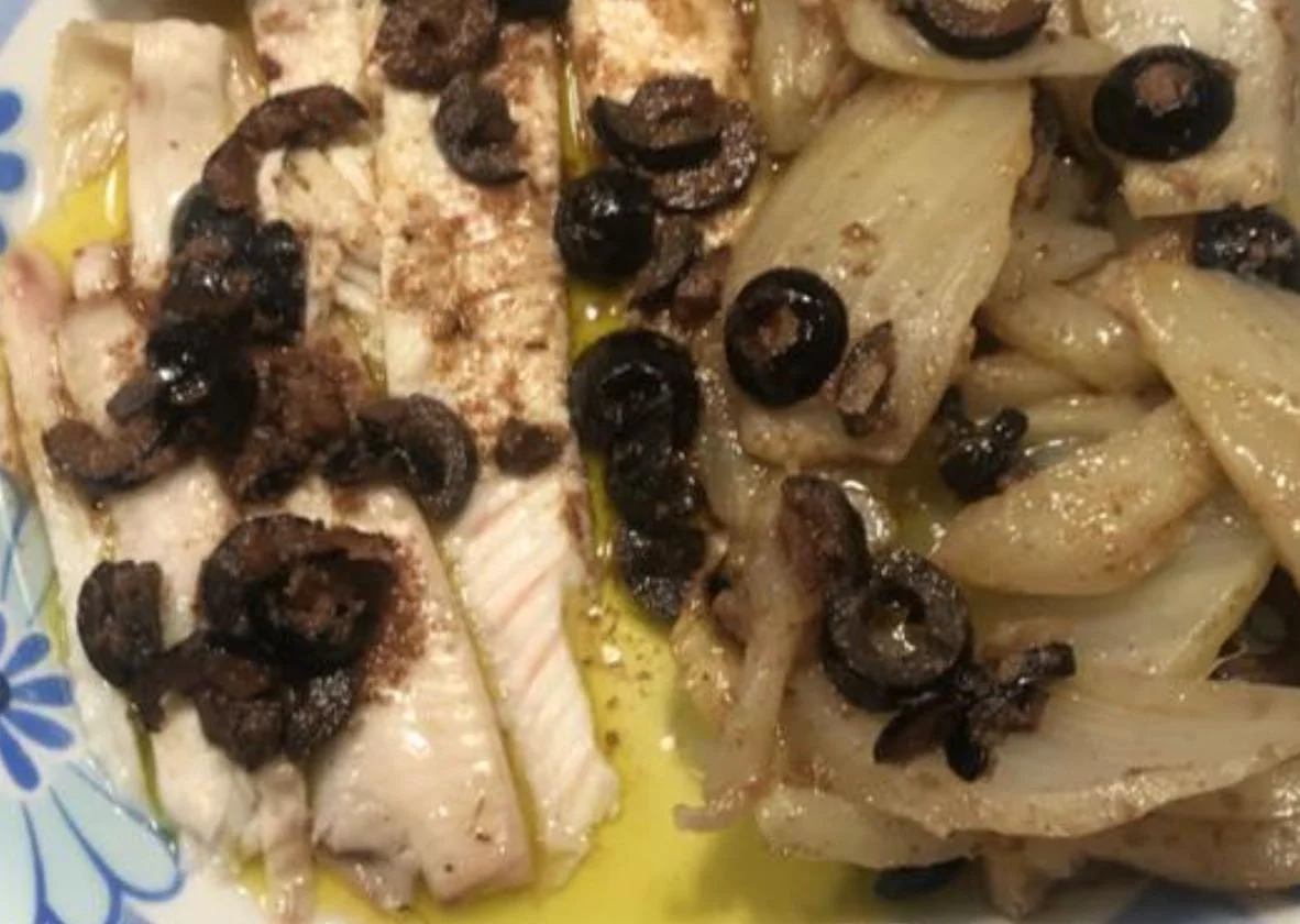 Filetti di sogliola alla saccense con finocchi e arance su piatto siciliano