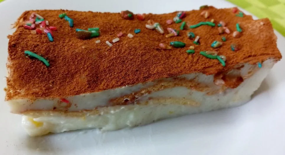 Testa di turco di Castelbuono servita in pirofila con strati di crema e sfoglia, decorata con cannella e gocce di cioccolato