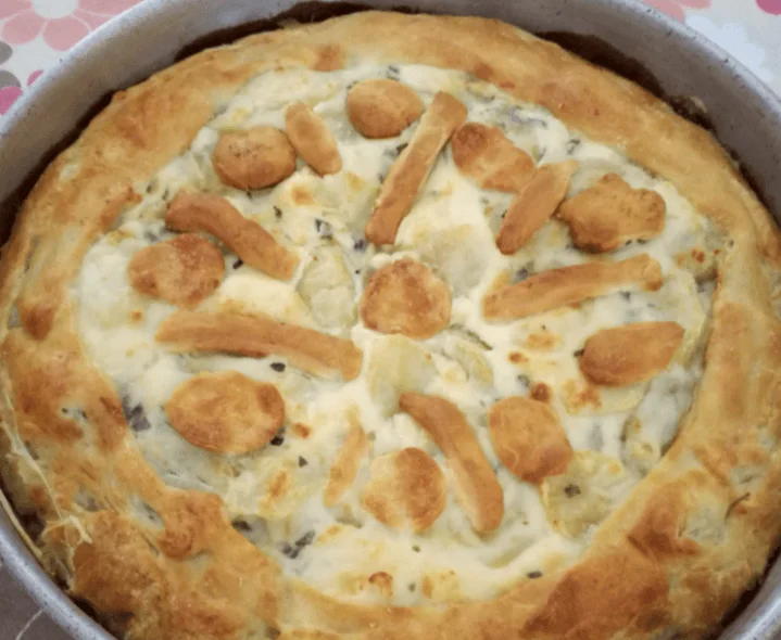 Torta di carciofi e patate dorata e rustica servita su piatto di ceramica siciliana